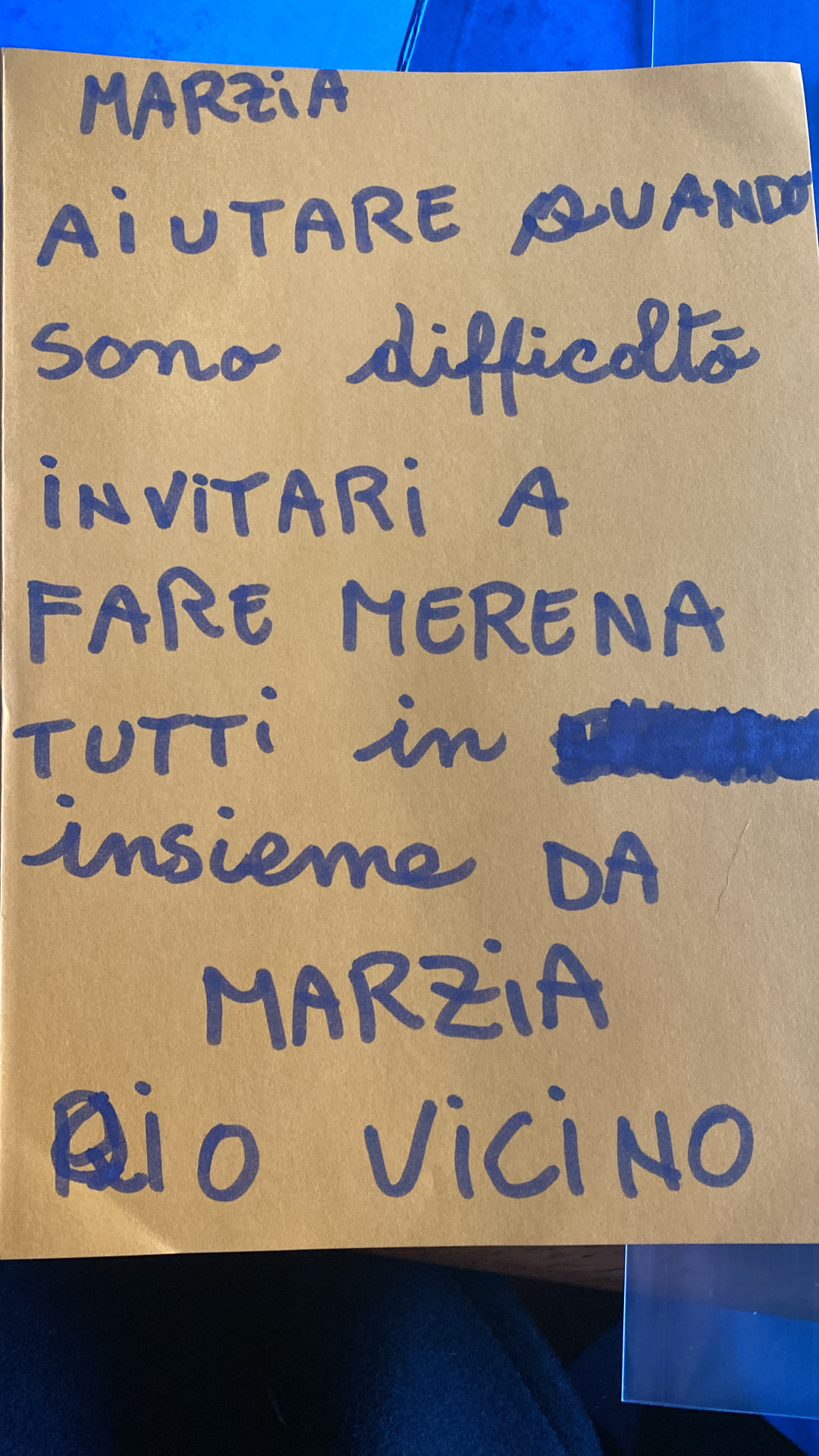 Cartello scritto a mano da Marzia: aiutare quando ci sono difficoltà, invitare a fare merenda tutti insieme